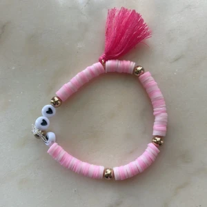 Armband - Här är ett rosa sommararmband, i både rosa och ljus rosa med några guldiga detaljer på och även en rosa liten mjuk toffs💕💗💗🌸15kr