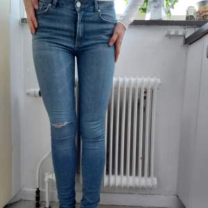 Ljusblå jeans slitna på knät tight modell