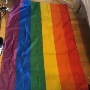 Pride flagga - I väldigt fint skick! Har bara använt den som dekoration i mitt rum. Storleken är 90 x 150 skriv om du vill ha fler bilder!
