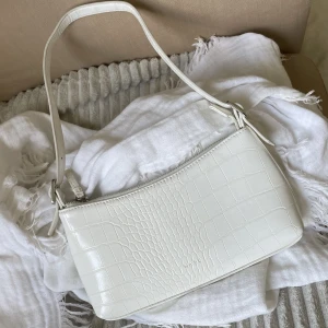 Vit axelväsla - Vit axelväska från nakd använd fåtal gånger nypris 349kr mitt pris 100kr. Tryck gärna på köp nu😊💕 (Om väskan inte är markerad som såld finns den kvar)