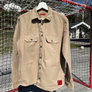 Hugo Boss jeansskjorta  - Knappt använd jeansskjorta av märket Hugo Boss Storlek S Färg beige  Nypris ca 1499