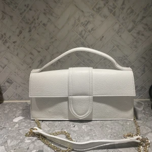 Vit väska i italienskt läder  - Använd 1 gång så i nyskick. Köpt i Italien, inköpspris 70€. Avtagbar axelrem. 