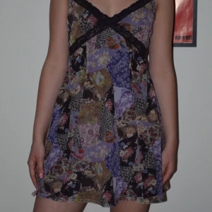 mini klänning med spets  - Frän klänning med mönster och spets! Modellen på bilden är 163 cm lång. Använd 1 gång men säljer pga inte min stil längre. Pruta funkar oftast!