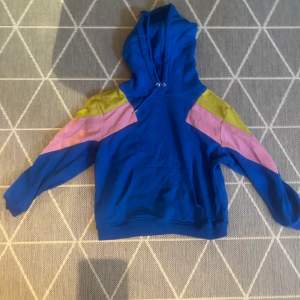 fin hoodie med förger inspirerade av 80-tals färger. verkligen ett skönt material.