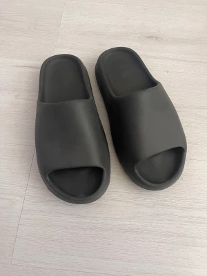 Yeezy Slide Onyx - Yeezy slides i storlek uk11/45.5 men sitter som 44. Bra skick, använda ca 5 ggr, kvitto finns från END.