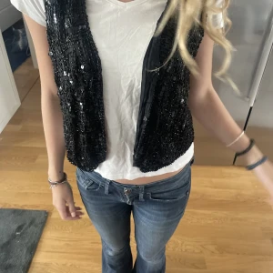 Glittrig väst - Säljer denna så himla snygga västen med glitter och paljetter. Passar perfekt till fest, middagar och lite finare tillfällen. Storlek okänd men passar nästan alla.