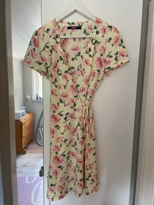 Klänning - Jätte fin gul blommig midsommar klänning. Använd en gång men lite för v ringad för mig. Stl. S. Frakt ingår inte!