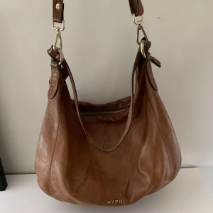 Vintage väska  - Vintage väska💽✨ har använts en del men kommer inte längre till användning.💕men är ändå fortfarande fräsch. Två band(den längre går att ta av och även justera) och även ett kortare band. Ett innerfack och ett ytterfack Läder👜✨ 150kr+frakt(betalas via swish