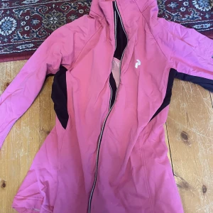 Peak performance träningsjacka - Peak performance träningsjacka i storlek S. Rosa med svarta detaljer. Dragkedja är trasig men kanske går att fixa. Skriv för fler bilder.