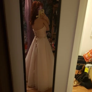 Balklänning  - Säljer balklänningen jag köpt till min student nu till sommaren eftersom den inte passade. den är andvänd en gång tidigare så typ helt ny. Den har en korsett överdel så den är justerbar och sju lager kjol på underdelen. Köpt för 3000. Nypris 6000