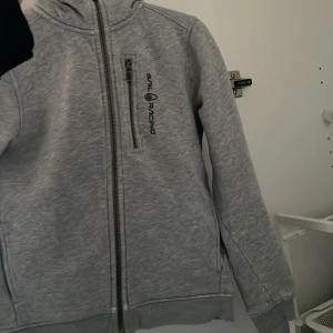 Grå sailracing hoodie - 140, inga defekter. 
