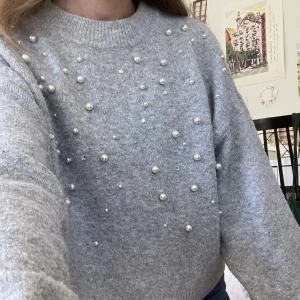 Stickad tröja med pärlor  - Mysig grå tröja med pärlor och lite ”diamanter” på. Jätteskön men säljer då den inte kommer till så mycket användning! Storlek S och sitter lite oversize på mig som brukar ha XS. 