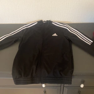 Adidas kofta/jacka - Snygg svart och vit adidas jacka/kofta. Passar mig bra förutom att ärmarna är för korta, jag är ca 1,65. 