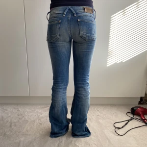 jeans - Lågmidjade jeans. Utsydda nedtill. Hon på bilden är 166 och midjemåttet på henne är 80cm och innerbenslängden på henne är ca 80cm (kanskd lite mindre). Hör av dig vid mer frågor💞