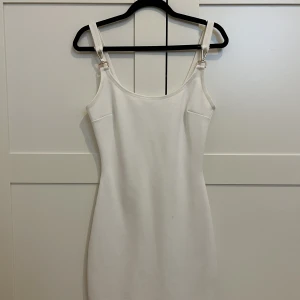 Vit klänning - Vit klänning med guld detaljer som passar perfekt för studenten, middag eller skolavslutning. Passar stl xxs-m.