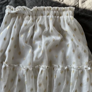 Vit kjol - Jag säljer denna jätte söta kjolen med guldiga prickar, den är i storlek s/m. Kjolen har en defekt vid resåret ( går att se på en av bilderna) men det är inget som syns när kjolen används. Nypris 400kr