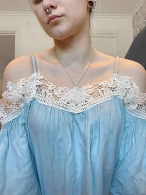 Ljusblå tröja - Ljusblå tröja som är öppen i axlarna, väldigt luftig och somrig