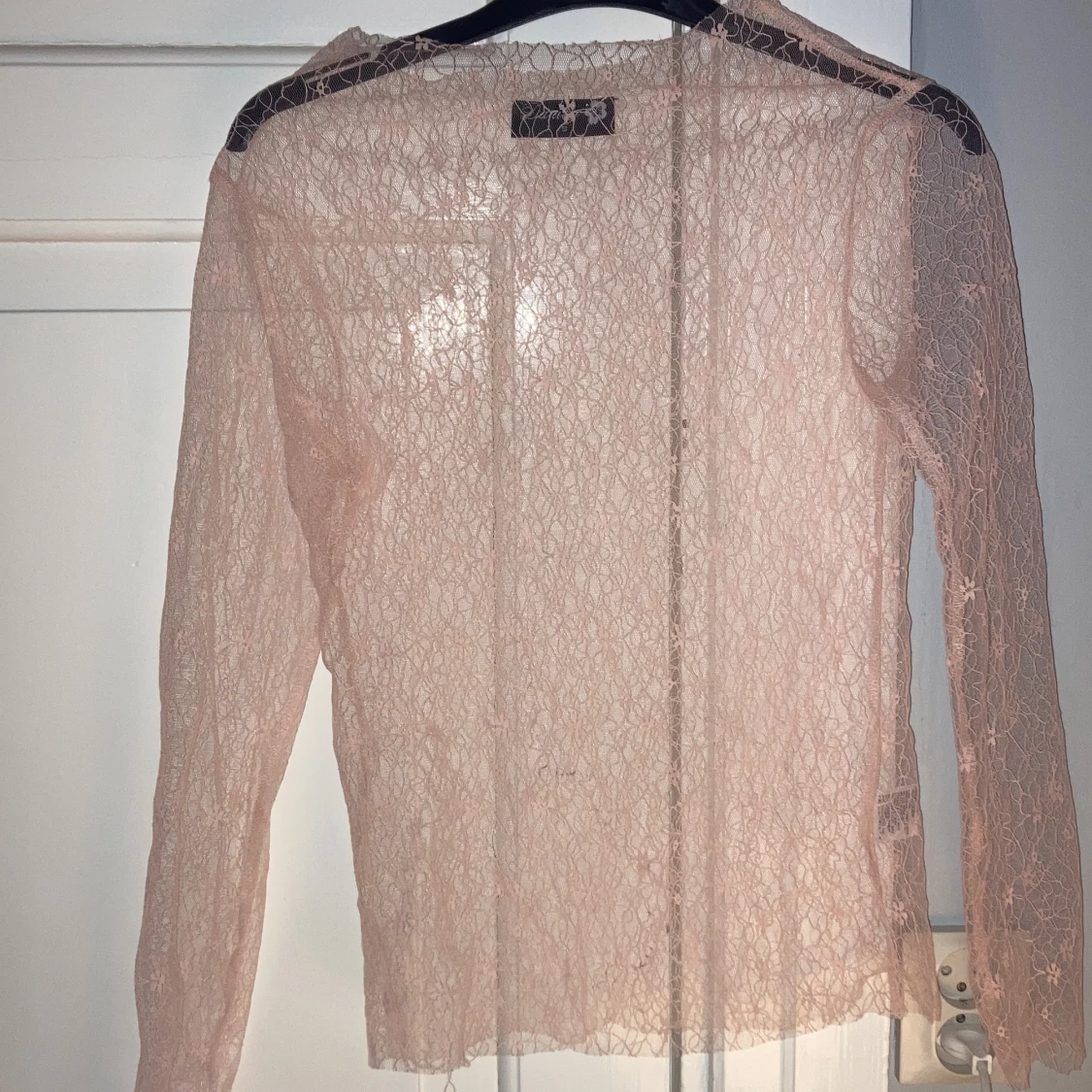 En ljusrosa tröja i hel spets