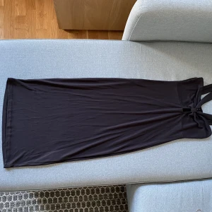 Svart klänning  - Svart klänning med axelband som ser knutna ut vid bysten. Axelbanden ser då ut som ett V. Skönt material och lagom längd (enligt mig). Använt vid få tillfällen, alltså väldigt bra skick. 