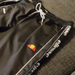 Ellese byxor - Fina Ellese byxor i sport/tränings material. Knappar längst sidorna av benen. Lågmidjade i storlek EU 38 passar dig som är 175-180 cm. Säljer då det är dam modell.   Nypris runt 700kr, pris kan diskuteras 