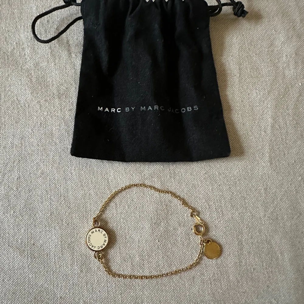 Säljer mitt Marc by Marc Jacobs armband i guld med vita detaljer. . Accessoarer.