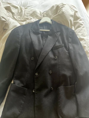 Dubbelknäppt kavaj från Massimo Dutti - Dubbelknäppt kavaj från Massimo Dutti i storlek Medium | 48. Färg = Svart.