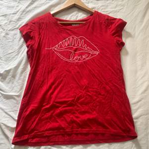 red t shirt with kiss lips on it. Small to size. I’m an M but it says XXL