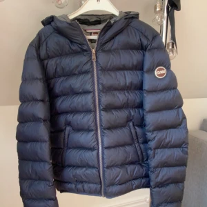 Colmar Jacka - Super fin colmar jacka i marinblå, grå inuti med en logga på armen. Köpt förra året använd fåtal gånger. Nyskick, Original pris: 3500kr Perfekt nu inför höst/vinter.