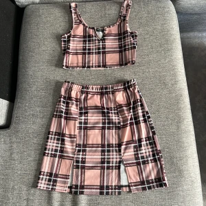 Matchande topp och kjol - En mönstrad matchande topp och kjol med slitt vid bröstet och vid låren.