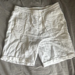 Skagen clothing, linnesshorts vit - Ett par vita linneshorts ifrån Skagen cltohing. Köpte i slutet av sommaren därav endast använda runt 10 gånger. Minimalt till inga tydliga tecken på användning. Väldigt bra skick. Nypris 529:-