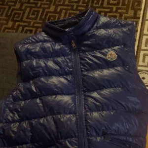 Moncler väst blå storlek L - En behaglig Moncler väst i storlek L. Den är köpt i början av året för 7000kr säljer den för 3000