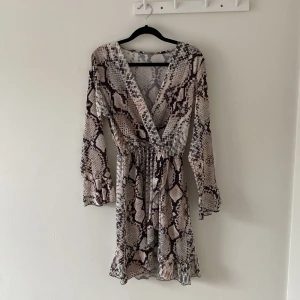 Klänning  - Mönstrad klänning från Gina Tricot, volang vid slutet av armen, storlek M