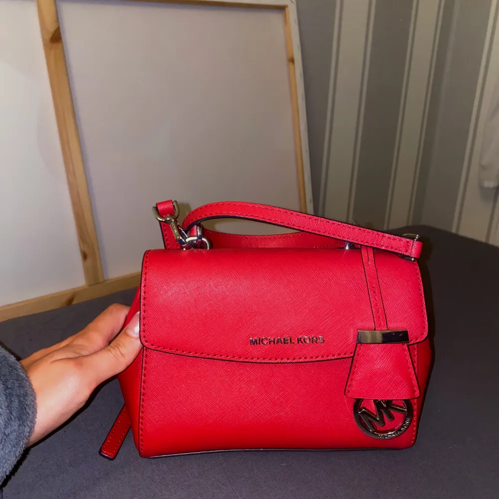 Jättefin röd liten axelremsväska väska från Michael Kors, den är använd ett 2-3 gånger, ser helt ny ut !! Skickar fler bilder ifall det önskas !!. Väskor.