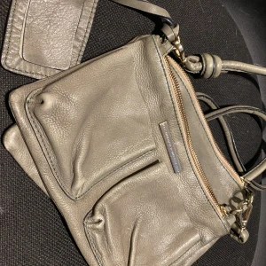 Day väska - Väska från Day i grönt skinn. Flera fack, lång axelrem. Passar till allt.  Lite använd. 