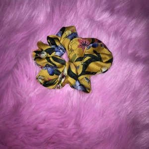 Scrunchie  - En gul scrunchie med blommor och liknande motiv, som inte har kommit till användning så jag säljer den här.