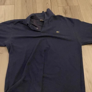  Mörkblå Lacoste piké  - Kommer inte till användning nypris 1000kr 