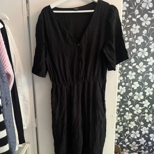 Jumpsuit med långa ben - Svart jumpsuit med långa ben och knappar fram från MONKI. Använd endast ett fåtal gånger.  Storlek M.