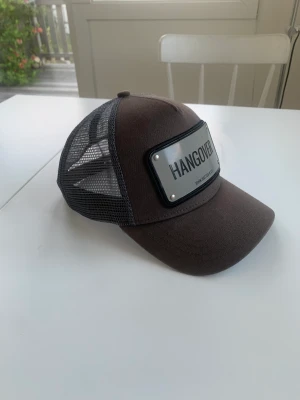 John Hatter Keps ”Hangover” - Tjena säljer min john hatter keps där det står Hangover. Kepsen har inga defekter, den är bara blekt. Köpt för 999 på hatstore