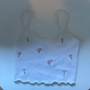 Vit blommigt linne - Linnet är ganska kort ungefär 24 cm där toppen slutar. (Banden räknas inte med)🌷 Storlek Xxs. Fint linne att ha nu i sommar. Obs det är bara linnet vi säljer.🩷🌸