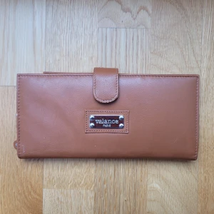 Stor plånbok  - Brun stor plånbok i läder eller fejkläder med många fack, har lite repor men i okej skick och den är väldigt rymlig. Nypris 299 kr