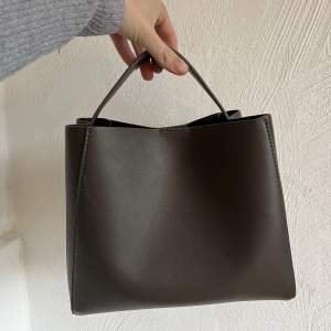 Väska från Gina Tricot, väldigt rymlig och i jättefint skick. Används som både handväska men också med axelband.