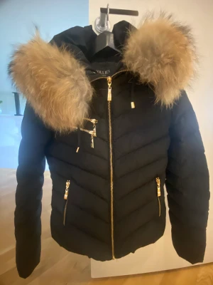 Vinter jacka - Säljer denna super fina jacka då den inte kommit till användning. Jackan är svart med guld detaljer och är i nytt skick. Ord pris 2999kr. 