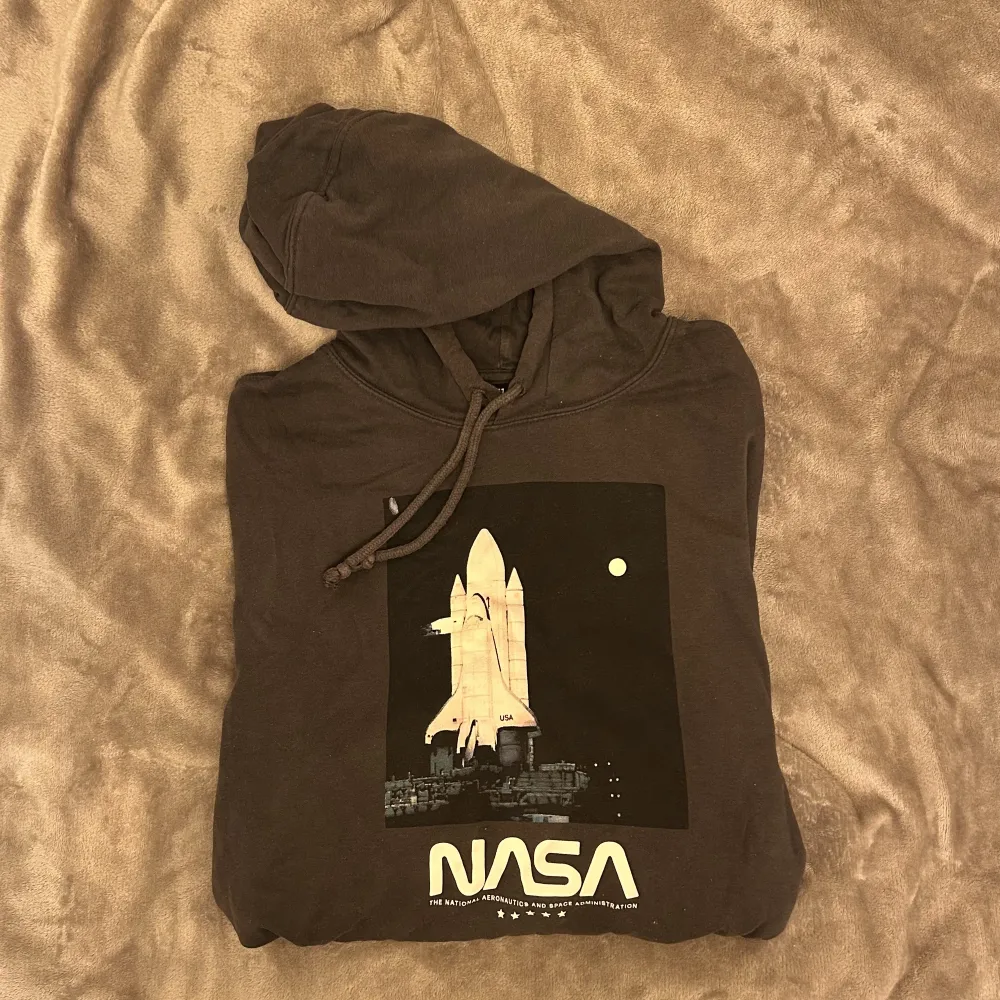 Grå snygg NASA hoodie från H&M. Väl använd men i gott skick. Oversized i modellen så passar fler storlekar. . Hoodies.
