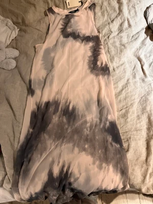 Genomskinlig klänning - Helt oanvänd genomskinlig klänning som kan användas med t.ex en underklänning eller bikini under, fin passform och aldrig använd