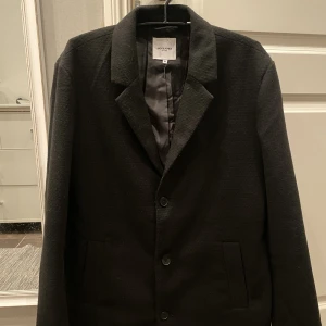 Jack & Jones rock/kappa - Säljer stilren och snygg rock/kappa från jack & jones som jag köpte förra vintern men knappt har använt och har nu köpt ny. Rocken är i XL men skulle säga att den passar L. Rocken är Varm och längre så den går strax över knäna.