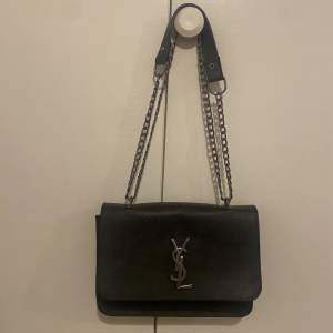 En liten handväska i märket YSL som går att använda som en axelväska också 