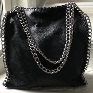 Svart Tiamoväska - Säljer denna jättefina och trendiga väska från tiamo. Med både ett yttefack och ett mindre innefack. Jag köpte den här på Plick men den har inte kommit till användning. Den är i jättebrasick. Perfekt nu till skolan/vardags. Skriv vid frågor💕💗🖤🖤💗💗💕