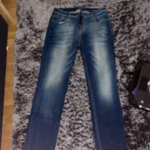 Blå jeans som har vita sträckar som design har inte används jätte bra kvalitet och jätte fina köpt för 500kr