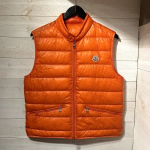 Moncler gui väst - Säljer nu denna feta moncler gui västen i orange. Storlek: 2 Skick: 8/10 Pris: 3299kr