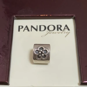 Pandora berlock nyskick retired  - Berlock i sterling silver,aldrig använt. Legat i original förpackning tillsammans med andra berlocker sen 2005/06. Ingen egen ask. Tillverkas ej mer. Märkt 925/ALE (pandoras stämpel) Heter: Retired Sterling Silver Daisy Flower Bead - 790187